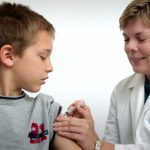 Ärztin verabreicht Kind eine Spritze.